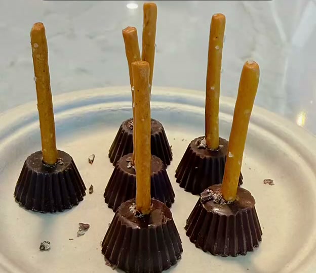 Full view of chocolate peanut butter cup and pretzel Halloween broom treats